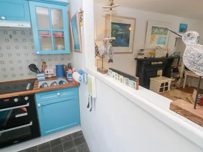 a kitchen with blue cabinets and a stove at 2 The Cottages in Ludgvan