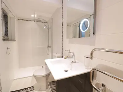 a white bathroom with a sink and a toilet at Treetops in Fowey