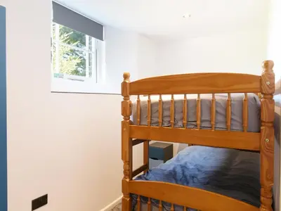 a wooden bunk bed in a room with a window at Moor View Chapel in Camelford