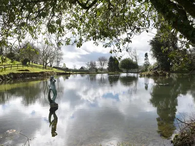 a body of water with a statue in the middle at Little Retreat in Liskeard