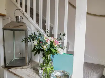 a vase with flowers on a table next to a staircase at Oh Buoy! in Charlestown