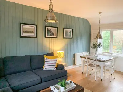 a living room with a blue couch and a table at Oh Buoy! in Charlestown