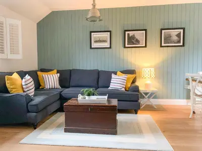 a living room with a blue couch and yellow pillows at Oh Buoy! in Charlestown
