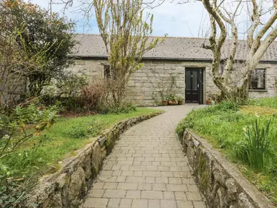 a stone house with a walkway in front of it at Brunnion Cottage in Hayle