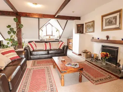 a living room with leather furniture and a fireplace at Brunnion House in Hayle