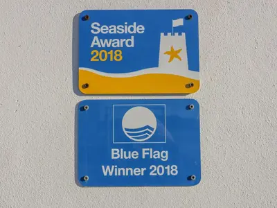 a sign for a blue flag winter at Buena Vista in Newquay