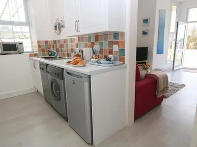 a kitchen with a sink and a washing machine at Beachcomber in Marazion
