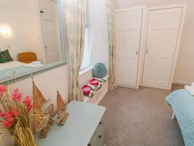 a room with a mirror and a bed and a table at Beachcomber in Marazion