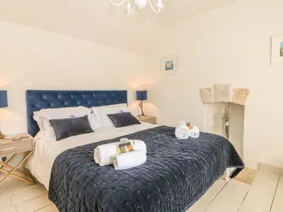 a bedroom with a large bed with towels on it at Sea Cliff Cottage in Pentewan