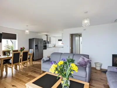 a living room with a couch and a table with flowers at Godrevy in St Ives