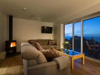 a living room with a couch and a large window at Godrevy in St Ives