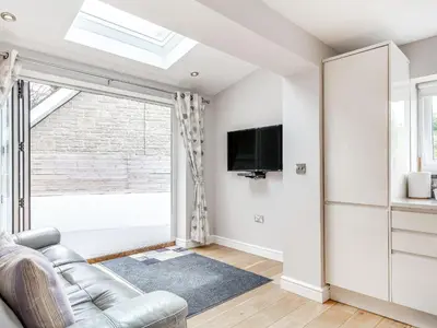 a living room with a couch and a tv at The Beach House in Crantock