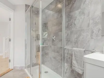 a bathroom with a shower with a glass door at The Beach House in Crantock