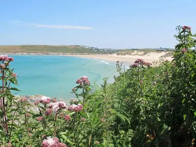 a view of a beach with pink flowers at Bay View House in Crantock