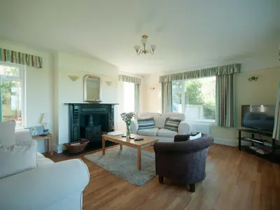a living room with a couch and a table at Bay View House in Crantock