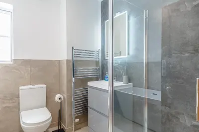 a bathroom with a toilet and a glass shower at Bay View House in Crantock