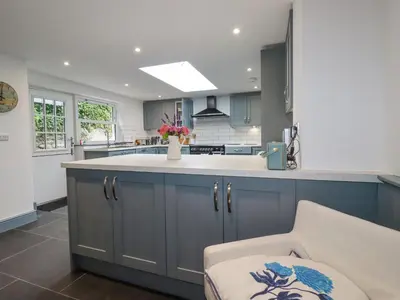 a kitchen with blue cabinets and a white counter top at Dale Cottage in Crantock