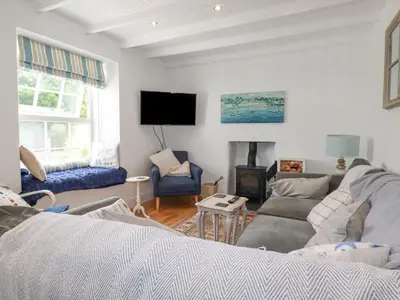 a living room with a couch and a fire place at Dale Cottage in Crantock