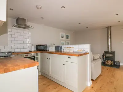 a kitchen with white cabinets and a stove at The Bolthole in Crantock