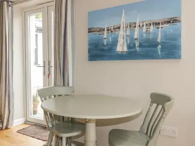 a dining room with a white table and chairs at The Bolthole in Crantock