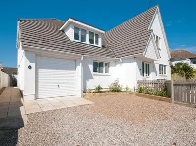 a white house with a garage in a driveway at Offshore in Newquay