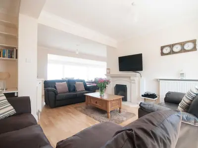 a living room with two couches and a fireplace at Crantock Bay House in Crantock