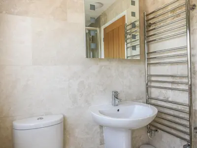 a bathroom with a sink and a toilet and a mirror at Crantock Bay House in Crantock