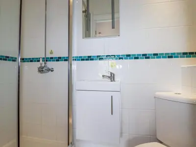 a white bathroom with a sink and a toilet at The Dunes in Crantock