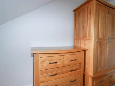 a wooden cabinet with a dresser in a room at The Dunes in Crantock