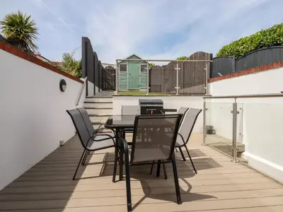 a patio with a table and chairs on a balcony at The Dunes in Crantock