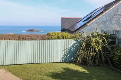 a white fence with a view of the ocean at Kittiwake in Crantock