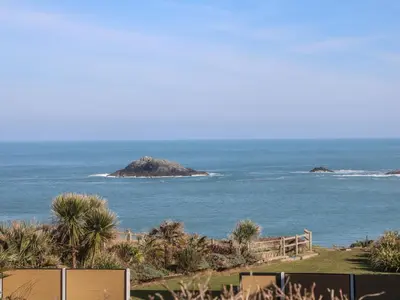 a view of the ocean with an island in the distance at Kittiwake in Crantock