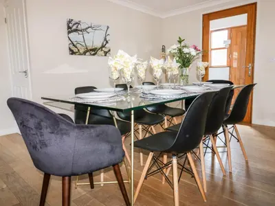 a dining room with a glass table and chairs at Carpe Diem in Crantock
