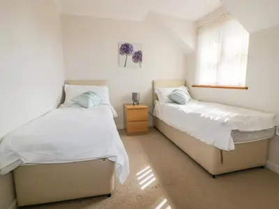 a bedroom with two beds and a window at Carpe Diem in Crantock