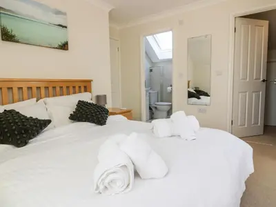 a bedroom with a white bed with towels on it at Carpe Diem in Crantock