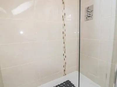 a shower with a glass door in a bathroom at Carpe Diem in Crantock