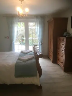 a bedroom with a bed and a dresser and a window at The Waterwheel in St Austell