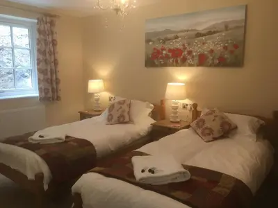 a bedroom with two beds with towels on them at The Waterwheel in St Austell