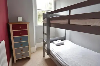 a bedroom with two bunk beds and a dresser at Roselyn House in Par