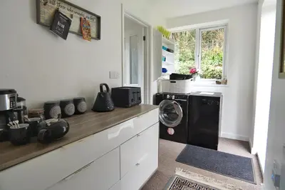 a kitchen with a washer and dryer on a counter at Roselyn House in Par