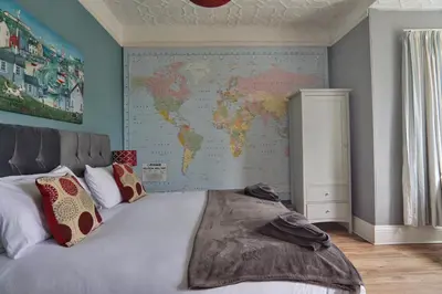 a bedroom with a map of the world on the wall at Roselyn House in Par