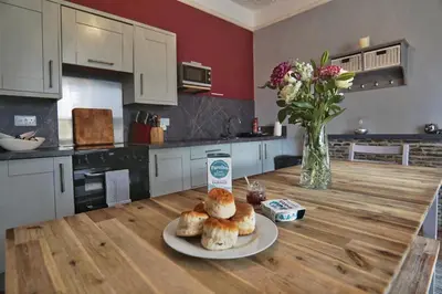 a kitchen with a table with a plate of pastries on it at Roselyn House in Par
