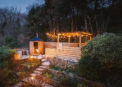a gazebo with lights in a garden at night at The Hideaway & Spa Terrace at Tregoose Old Mill in Newquay