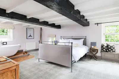 a bedroom with a large bed and a bath tub at The Hideaway & Spa Terrace at Tregoose Old Mill in Newquay