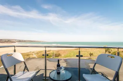 a balcony with a table and chairs and the ocean at The Penellen guest accommodation room only in Hayle