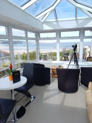 a living room with a table and chairs and windows at The Penellen guest accommodation room only in Hayle