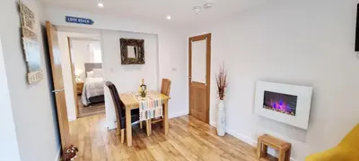 a living room with a table and a bedroom at Romantic Hot Tub Breaks Marthys House Looe Polperro Talland Bay in Looe