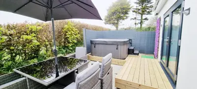 a patio with a table and an umbrella at Romantic Hot Tub Breaks Marthys House Looe Polperro Talland Bay in Looe