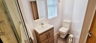 a bathroom with a sink and a toilet and a mirror at Romantic Hot Tub Breaks Marthys House Looe Polperro Talland Bay in Looe