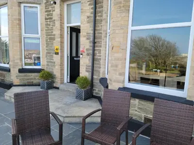 two chairs sitting on a patio in front of a building at Geckos Rest in Newquay